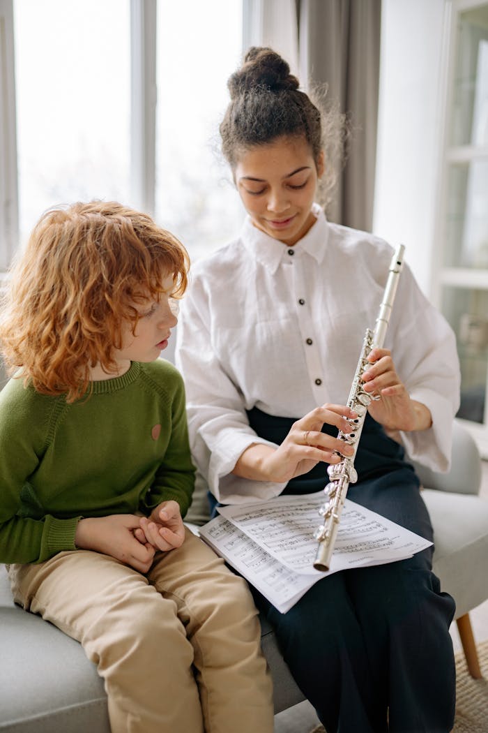 Teacher instructs a boy on flute play, focusing on musical notation and technique.